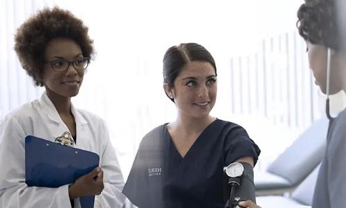 Nurse Teacher Showing Nursing Student How to Take Blood Pressure