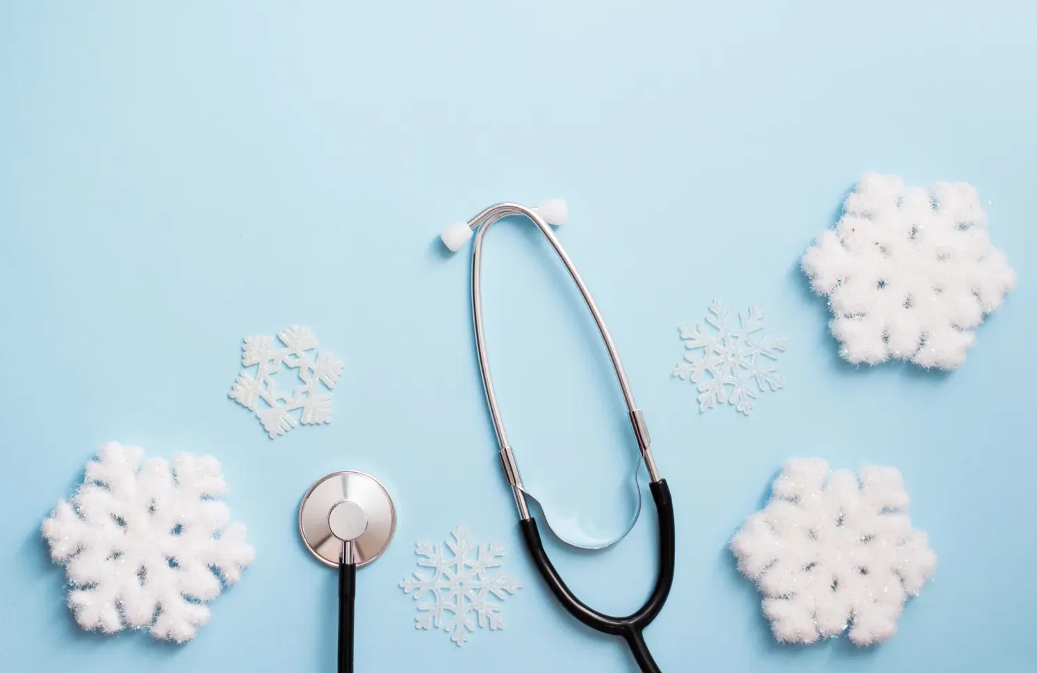 blue background with stethoscope and snowflakes, medical winter holiday. copy space