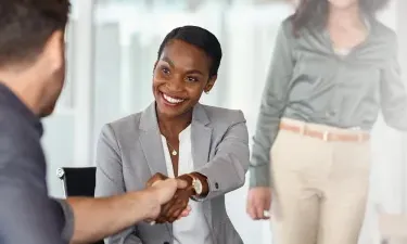 Atlanta business woman with online MBA shaking hands after securing deal